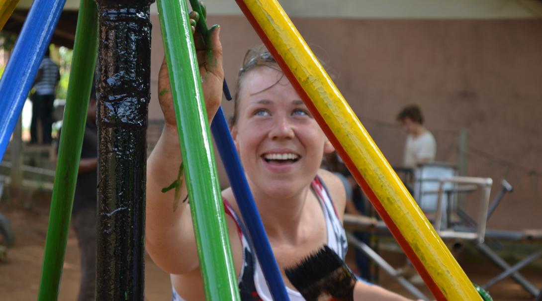 A Projects Abroad volunteer building in Ghana, helps paint a playground A volunteer paints a playground as part of her construction volunteering in Ghana